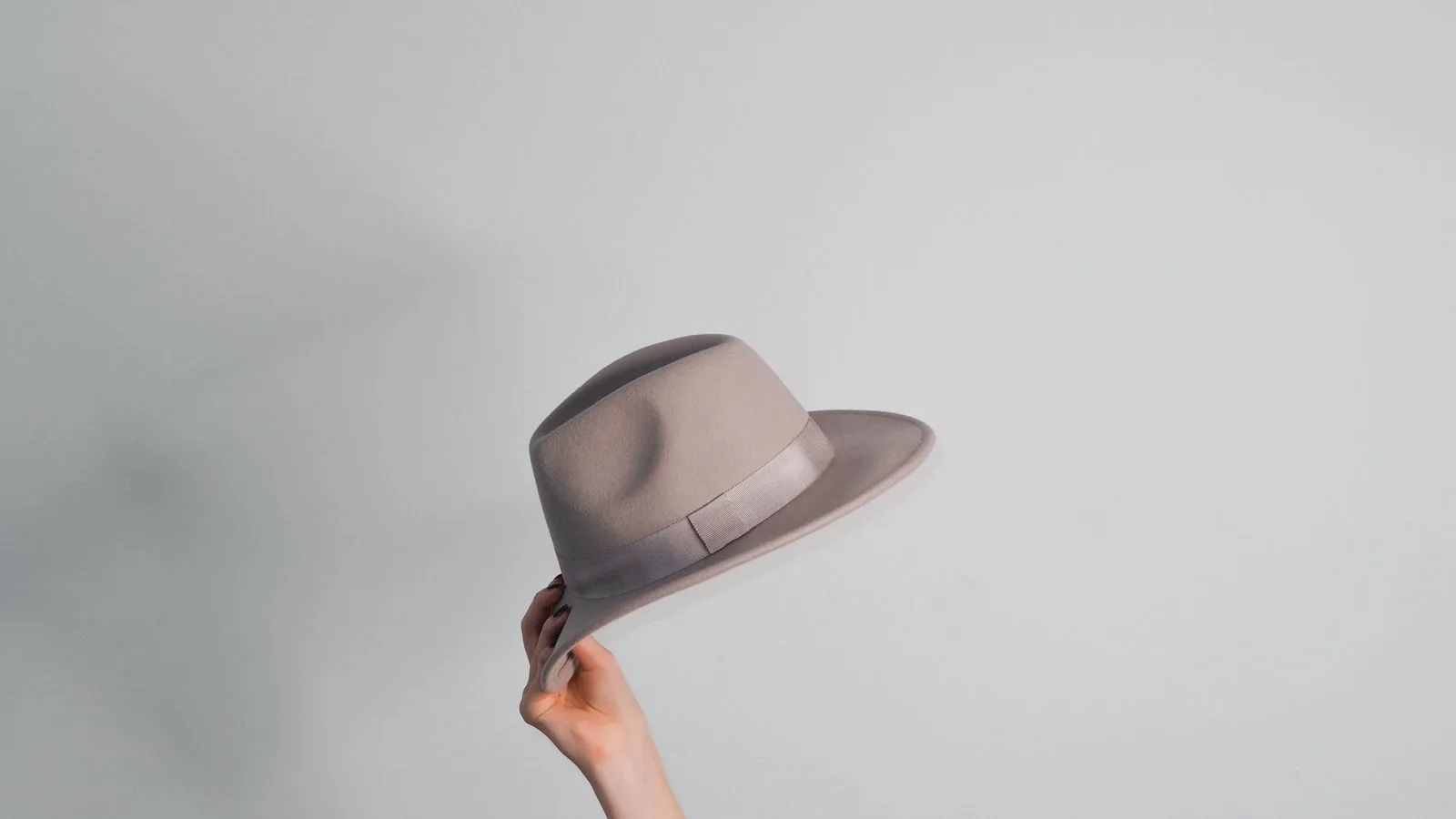 White hat link building — a light fedora held against a white background